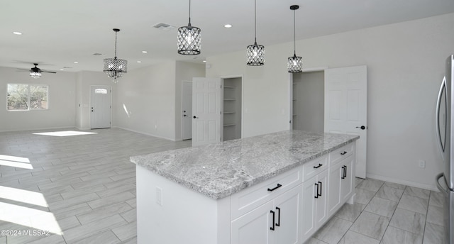 kitchen featuring visible vents, a center island, hanging light fixtures, white cabinetry, and recessed lighting