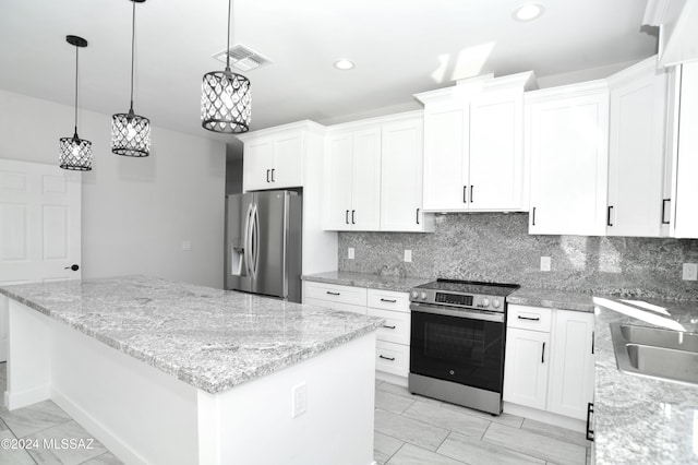 kitchen featuring visible vents, a kitchen island, stainless steel appliances, white cabinetry, and backsplash