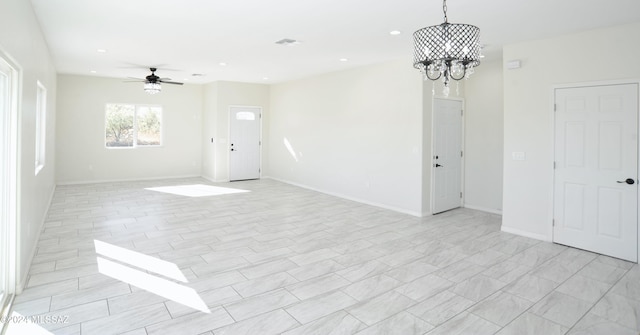 spare room featuring recessed lighting, visible vents, baseboards, and ceiling fan with notable chandelier