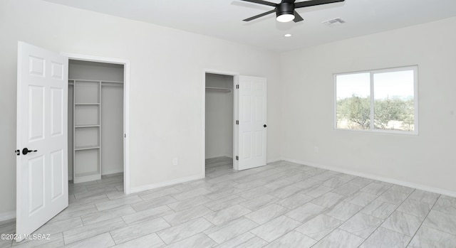 unfurnished bedroom featuring a ceiling fan, visible vents, baseboards, and two closets