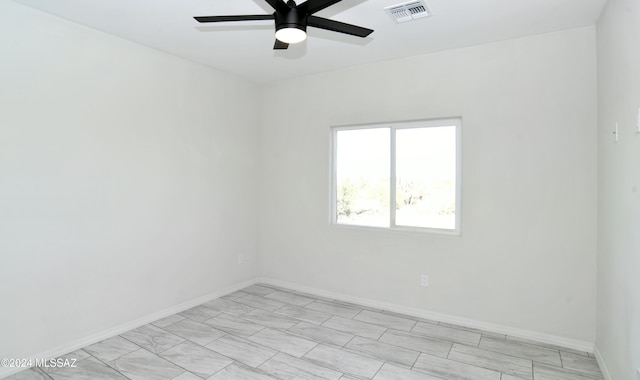 empty room featuring a ceiling fan, visible vents, and baseboards