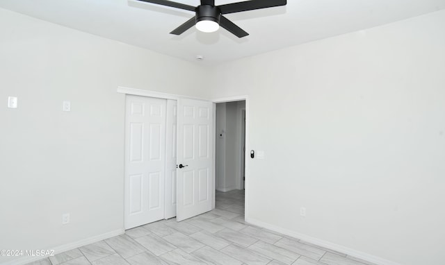 unfurnished bedroom featuring a ceiling fan, a closet, and baseboards