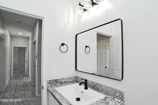 bathroom featuring marble finish floor, vanity, and baseboards