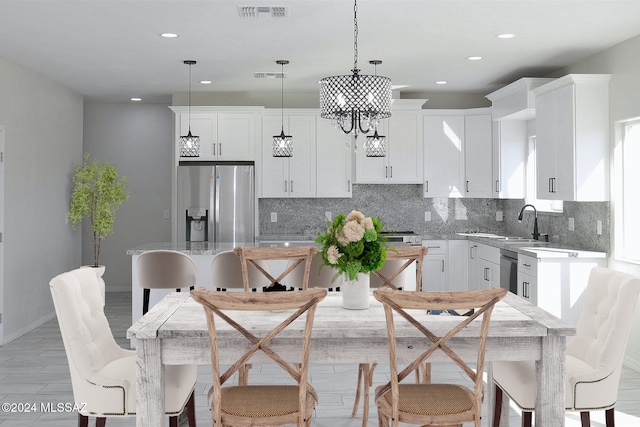 kitchen with visible vents, stainless steel appliances, decorative backsplash, and decorative light fixtures