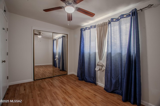 unfurnished bedroom featuring lofted ceiling, light wood finished floors, a closet, and a ceiling fan