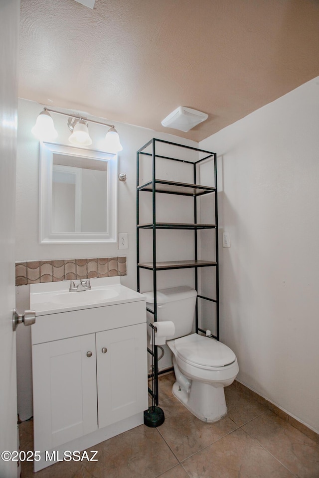 bathroom with vanity, toilet, and tile patterned floors