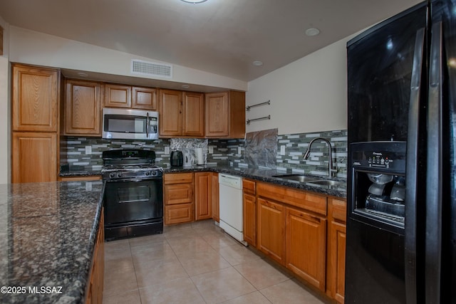 kitchen featuring light tile patterned floors, a sink, visible vents, black appliances, and brown cabinetry