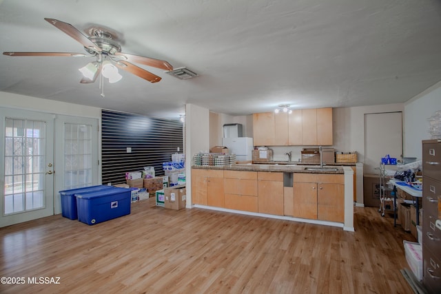 kitchen featuring a sink, visible vents, french doors, light brown cabinetry, and light wood finished floors