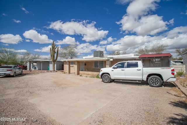 ranch-style home featuring brick siding and cooling unit