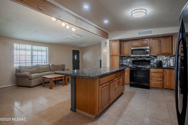 kitchen with light tile patterned floors, visible vents, a center island, black appliances, and backsplash