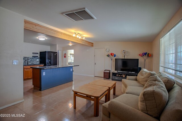 living area featuring baseboards, visible vents, and light tile patterned flooring