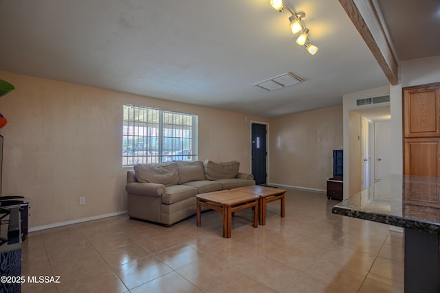 living room with beam ceiling, light tile patterned flooring, visible vents, and baseboards