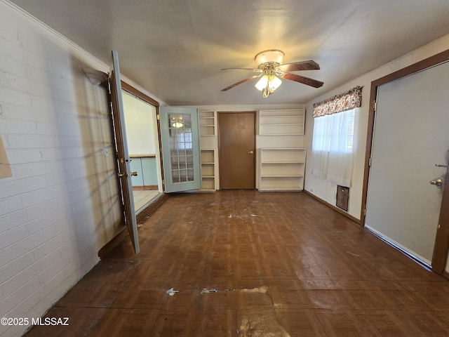 interior space with brick wall and ceiling fan