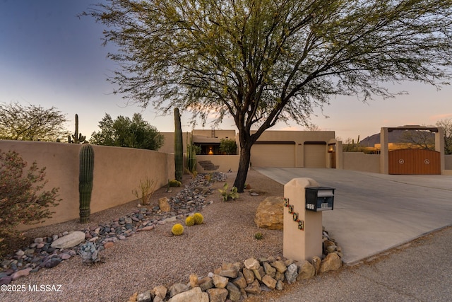 exterior space with driveway, a fenced front yard, and stucco siding