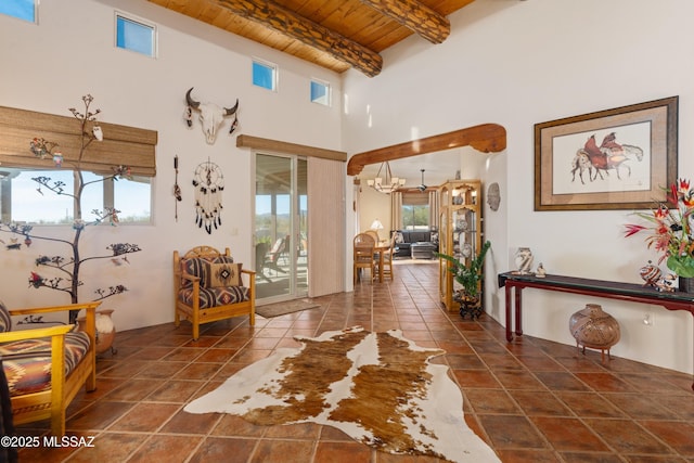 interior space featuring tile patterned flooring, wooden ceiling, a chandelier, and beam ceiling