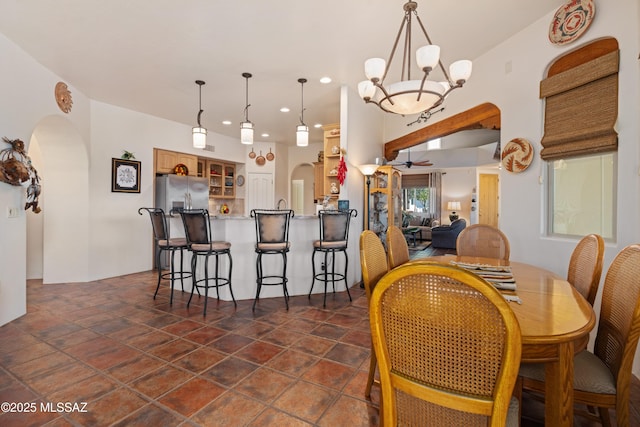 dining area with recessed lighting, arched walkways, and a notable chandelier