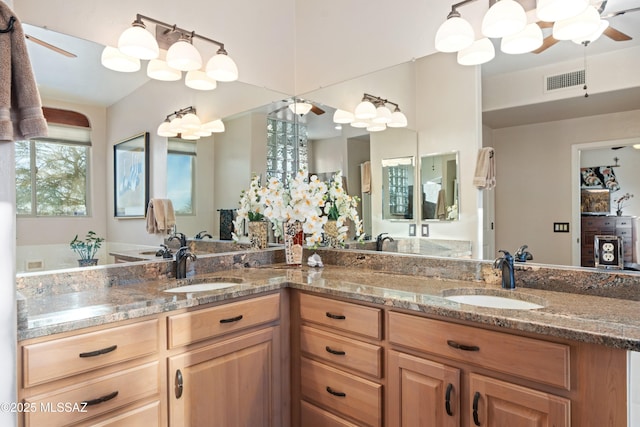 bathroom featuring a sink, visible vents, ceiling fan, and double vanity