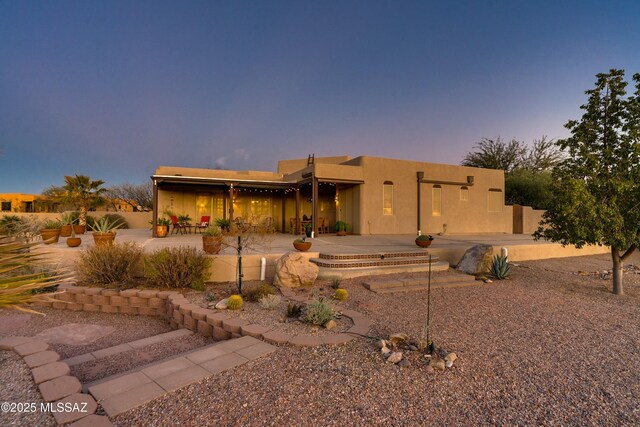 pueblo-style home with a patio