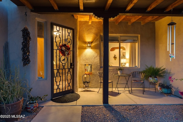 entrance to property featuring stucco siding