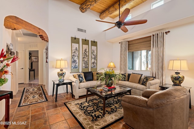 living room with visible vents, beam ceiling, a ceiling fan, arched walkways, and wood ceiling