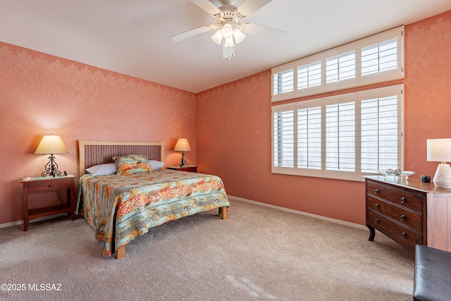 carpeted bedroom with ceiling fan and baseboards