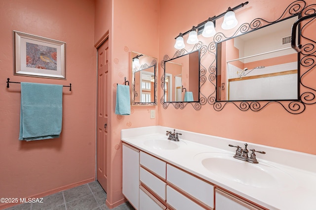 bathroom featuring double vanity, tile patterned flooring, visible vents, and a sink