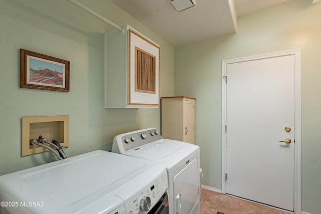 laundry area featuring cabinet space, washer and clothes dryer, and light tile patterned floors