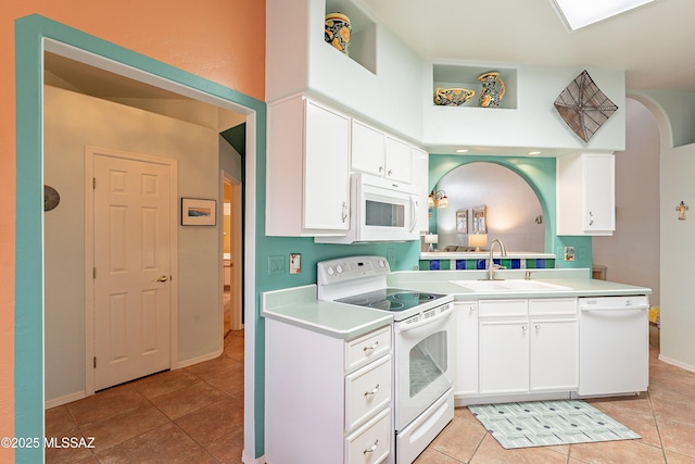 kitchen with light tile patterned floors, white appliances, a sink, white cabinetry, and light countertops