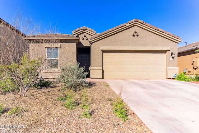 view of front of house with a garage, driveway, a tiled roof, and stucco siding