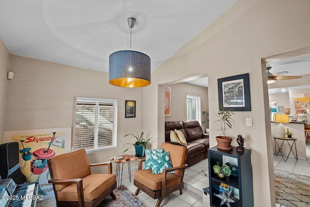 sitting room with lofted ceiling, a ceiling fan, and light tile patterned flooring