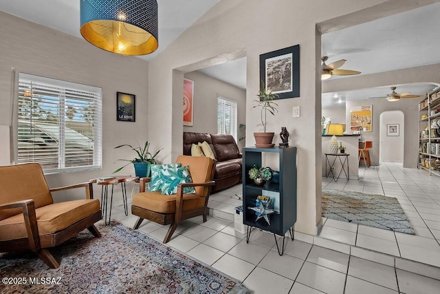 sitting room with arched walkways, ceiling fan, and light tile patterned flooring