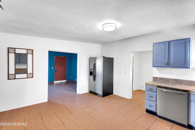 757 W Glenn St, Tucson, AZ 85705 - kitchen with appliances with stainless steel finishes, light tile patterned floors, blue cabinetry, and tile countertops
