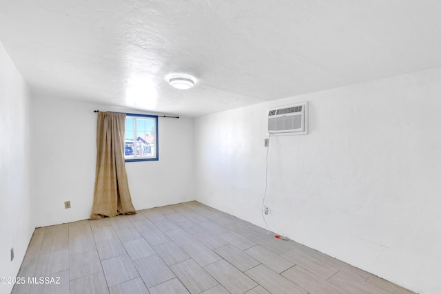 spare room featuring a textured ceiling and an AC wall unit