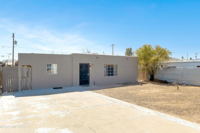 back of house featuring a patio area, fence, and stucco siding