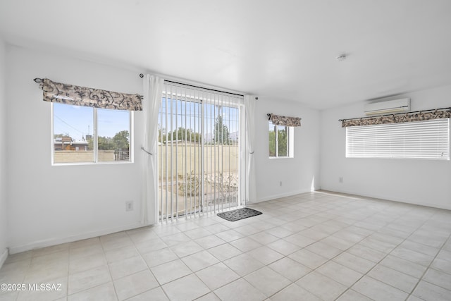 unfurnished room featuring baseboards and an AC wall unit