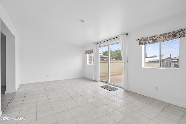 unfurnished room featuring light tile patterned floors and baseboards