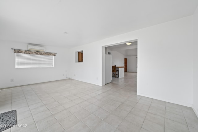 unfurnished room with baseboards and a wall mounted air conditioner