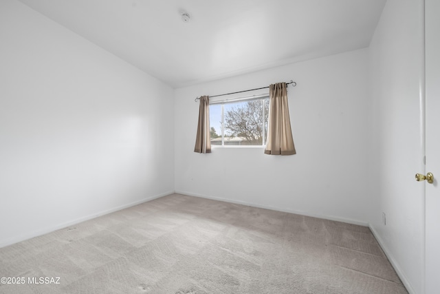 carpeted empty room featuring baseboards