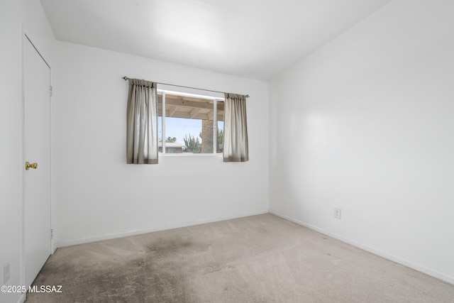 empty room featuring carpet floors and baseboards