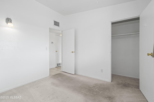 unfurnished bedroom featuring baseboards, visible vents, a closet, and carpet flooring