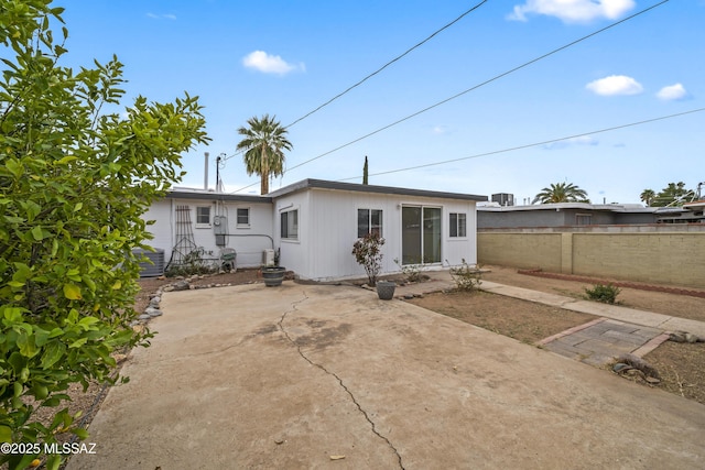 rear view of property with fence and a patio