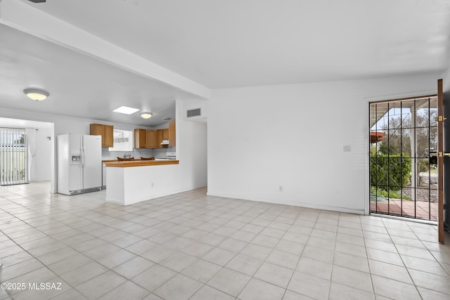 unfurnished living room with lofted ceiling with beams, light tile patterned flooring, visible vents, and a healthy amount of sunlight