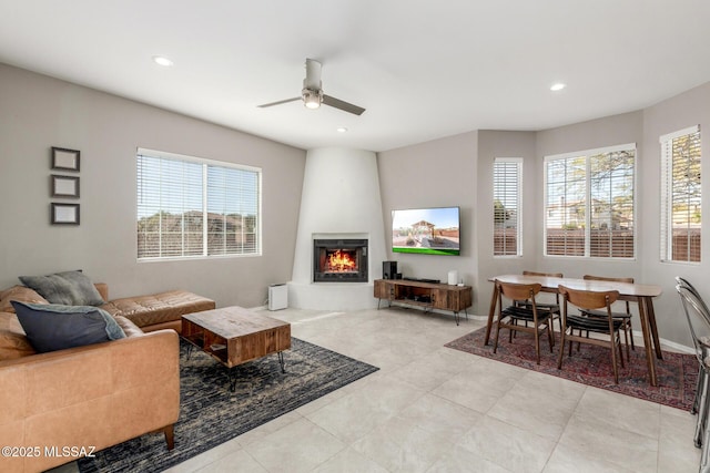 living area with a wealth of natural light, a fireplace, baseboards, and recessed lighting