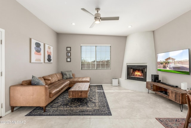 living area featuring a fireplace, baseboards, a ceiling fan, and recessed lighting