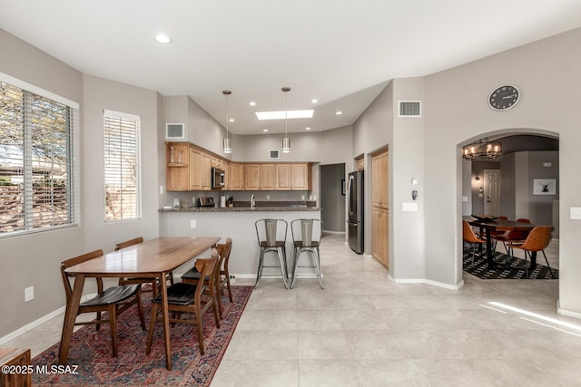 dining space with baseboards, visible vents, arched walkways, and recessed lighting