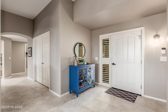 entrance foyer with arched walkways and baseboards