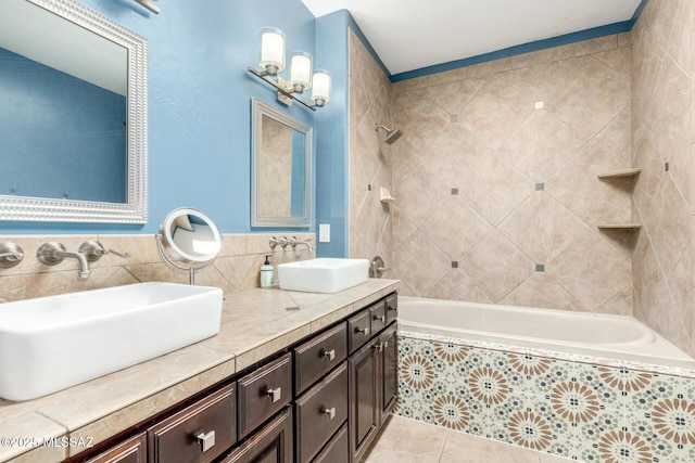 full bath featuring tiled shower / bath, double vanity, tile patterned flooring, and a sink