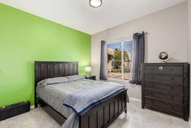 bedroom with light tile patterned flooring and baseboards