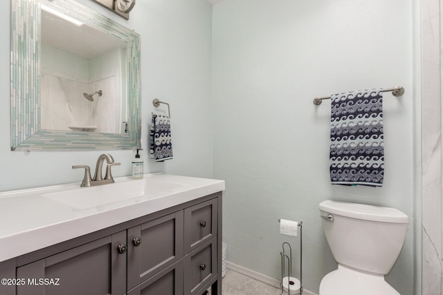 full bath featuring a shower, vanity, toilet, and baseboards