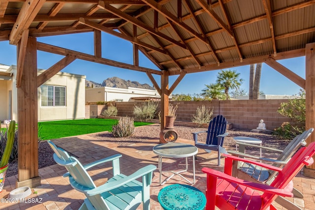 view of patio featuring a mountain view, a gazebo, and fence